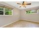 Well-lit bedroom featuring tile floors, two windows with bright green backyard views, and neutral walls at 2632 Handley Blvd, Lakeland, FL 33803