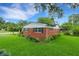 Charming red brick home with lush landscaping, mature trees and green lawn at 2632 Handley Blvd, Lakeland, FL 33803