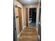 Hallway with brick wall, wood floor, and shelving visible into garage at 2632 Handley Blvd, Lakeland, FL 33803