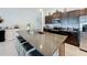 Kitchen island with granite countertops, dark cabinets, stainless steel appliances, and seating for three at 2929 Flying Blackbird Rd, Bartow, FL 33830