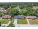 Aerial view of the cozy home nestled in a tranquil, tree-filled neighborhood with lush greenery at 3016 Reiter Dr, Auburndale, FL 33823