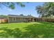 Large backyard with new fence, covered patio, and lush green lawn at 3016 Reiter Dr, Auburndale, FL 33823