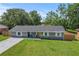 Charming single-story home with a well-manicured lawn and a welcoming yellow front door at 3016 Reiter Dr, Auburndale, FL 33823