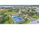 This aerial view shows community amenities including a pool, clubhouse, tennis courts and manicured entrance at 3121 Highlands By The Lake Way, Lakeland, FL 33812