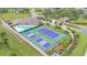 Aerial view showcasing the community pool, clubhouse, tennis courts and lush landscaping at 3121 Highlands By The Lake Way, Lakeland, FL 33812