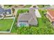 Aerial view of the backyard showcasing a screened-in pool, verdant landscaping, and green lawn at 3121 Highlands By The Lake Way, Lakeland, FL 33812