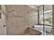 Luxurious bathroom featuring a tiled walk-in shower with a bench and modern standalone tub at 3121 Highlands By The Lake Way, Lakeland, FL 33812