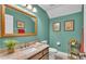 Inviting bathroom features a vanity with marble countertop, complemented by soft teal walls and gold-framed artwork at 3121 Highlands By The Lake Way, Lakeland, FL 33812