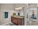 Bathroom featuring granite counters, wood cabinets and a large mirror with decorative lighting at 3121 Highlands By The Lake Way, Lakeland, FL 33812