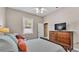 Cozy bedroom features a bed, dresser with a TV, and comfortable chair at 3121 Highlands By The Lake Way, Lakeland, FL 33812