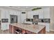Modern kitchen features white cabinetry, stainless steel appliances, and a large granite island at 3121 Highlands By The Lake Way, Lakeland, FL 33812