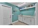 Bright laundry room featuring white cabinets, a sink with a marble countertop, and a door that leads outside at 3121 Highlands By The Lake Way, Lakeland, FL 33812
