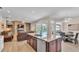 Open living space features modern kitchen island, fireplace, living area and pool views at 3121 Highlands By The Lake Way, Lakeland, FL 33812
