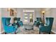 Comfortable sitting area features four blue chairs, an ottoman, and a doorway to the patio at 3121 Highlands By The Lake Way, Lakeland, FL 33812
