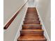 Wood staircase with white risers and a wood handrail going upstairs at 3121 Highlands By The Lake Way, Lakeland, FL 33812