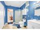 Bright bathroom with blue walls, a glass-enclosed shower, white vanity, and unique seashell chandelier at 322 Ne 9Th St, Mulberry, FL 33860