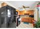 Functional kitchen with wood cabinets, black appliances, and ample counter space for meal preparation at 322 Ne 9Th St, Mulberry, FL 33860