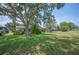 Large backyard featuring a mix of grassy areas and mature trees, providing ample space for outdoor activities at 5 Pine Run, Haines City, FL 33844