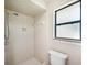 Bathroom with tiled shower and toilet, and window with natural light at 5 Pine Run, Haines City, FL 33844