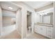 A hallway leading to a bathroom with a white vanity and granite countertop at 5 Pine Run, Haines City, FL 33844