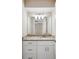 Bathroom with white cabinets, granite countertop, and large mirror at 5 Pine Run, Haines City, FL 33844
