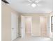 A bedroom with multiple closets and doors, neutral walls and carpet, and a ceiling fan at 5 Pine Run, Haines City, FL 33844
