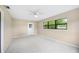 A sunny bedroom with neutral walls, carpet and ceiling fan, featuring a big window at 5 Pine Run, Haines City, FL 33844