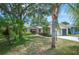Inviting single-story home with mature trees, a well-manicured lawn, and tropical landscaping at 5 Pine Run, Haines City, FL 33844