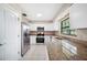 Well-appointed kitchen with stainless steel appliances, granite countertops, and bright white cabinetry at 5 Pine Run, Haines City, FL 33844