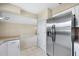 Modern kitchen with stainless steel refrigerator, granite countertops, white cabinets, and tiled floor at 5 Pine Run, Haines City, FL 33844
