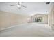 Bright living room with plush carpeting, vaulted ceiling, neutral walls, and view of the front yard at 5 Pine Run, Haines City, FL 33844