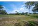 Vast open space featuring a mix of grassy areas and sandy patches with mature trees in the distance at 5 Pine Run, Haines City, FL 33844