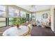 Cozy sunroom featuring an oval table and wicker seating with views of the surrounding greenery at 5 Pine Run, Haines City, FL 33844