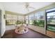 Bright sunroom featuring a ceiling fan, tile floors and multiple windows with natural light and outdoor views at 5 Pine Run, Haines City, FL 33844