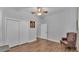 Bedroom with wood floors features a closet and a chair at 535 N Todhunter Way, Lake Alfred, FL 33850