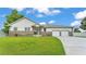 Charming single-story home featuring stone accents, a manicured lawn, and a two-car garage at 535 N Todhunter Way, Lake Alfred, FL 33850