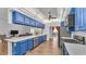 Gourmet kitchen with quartz countertops, stainless steel appliances, and bright blue cabinetry at 535 N Todhunter Way, Lake Alfred, FL 33850