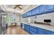 Well-lit kitchen boasting bright blue cabinets, quartz countertops, and stainless steel appliances at 535 N Todhunter Way, Lake Alfred, FL 33850