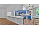 Bright kitchen featuring stylish blue cabinets, stainless appliances, spacious counter, and modern wood flooring at 535 N Todhunter Way, Lake Alfred, FL 33850
