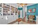Inviting living room featuring built-in bookshelves, complemented by wood flooring and an accent wall at 535 N Todhunter Way, Lake Alfred, FL 33850