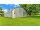 Spacious metal outbuilding on a green lawn, perfect for storage or workshop, and adjacent to mature trees at 535 N Todhunter Way, Lake Alfred, FL 33850