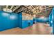Large versatile room with blue paneled walls, modern lighting, and wood flooring, perfect for customizable spaces at 535 N Todhunter Way, Lake Alfred, FL 33850
