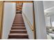 A classic wooden stairway leading to an upper level, showcasing natural light and simple, clean design at 535 N Todhunter Way, Lake Alfred, FL 33850