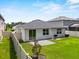 A private backyard with a small patio area, lush green grass, and a fenced perimeter at 546 Scott Lake Creek Ln, Lakeland, FL 33813