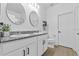 Bathroom showcasing dual sinks with granite countertops, white cabinets, and modern fixtures at 546 Scott Lake Creek Ln, Lakeland, FL 33813