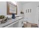 Bathroom boasts granite countertops, a decorative mirror, and modern sink fixtures at 546 Scott Lake Creek Ln, Lakeland, FL 33813