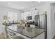 Modern kitchen with granite countertops, stainless steel appliances, white cabinetry, and a kitchen island at 546 Scott Lake Creek Ln, Lakeland, FL 33813
