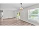 Open dining area with stylish chandelier, wood-look floors, and sliding doors to the lanai at 6 Rosewood Dr, Davenport, FL 33837