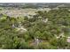 Expansive aerial view showcases the home's setting amongst mature trees in a quiet neighborhood at 6001 Sweet Gum Run, Bartow, FL 33830