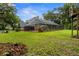 Wide shot of the backyard lawn and enclosed pool with screened enclosure at 6001 Sweet Gum Run, Bartow, FL 33830